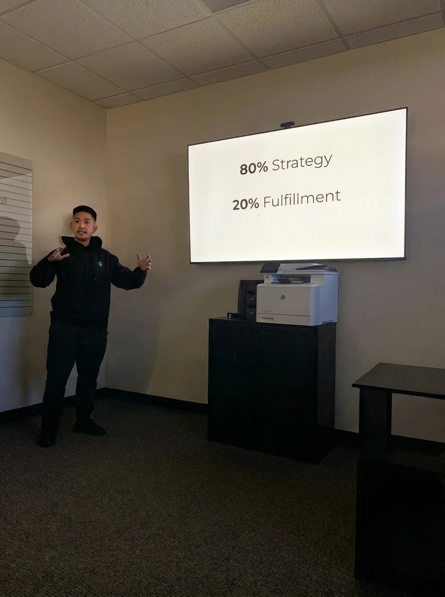 A CRE8R strategy session: presenting to the team in front of a slide reading 80% strategy, 20% fulfillment